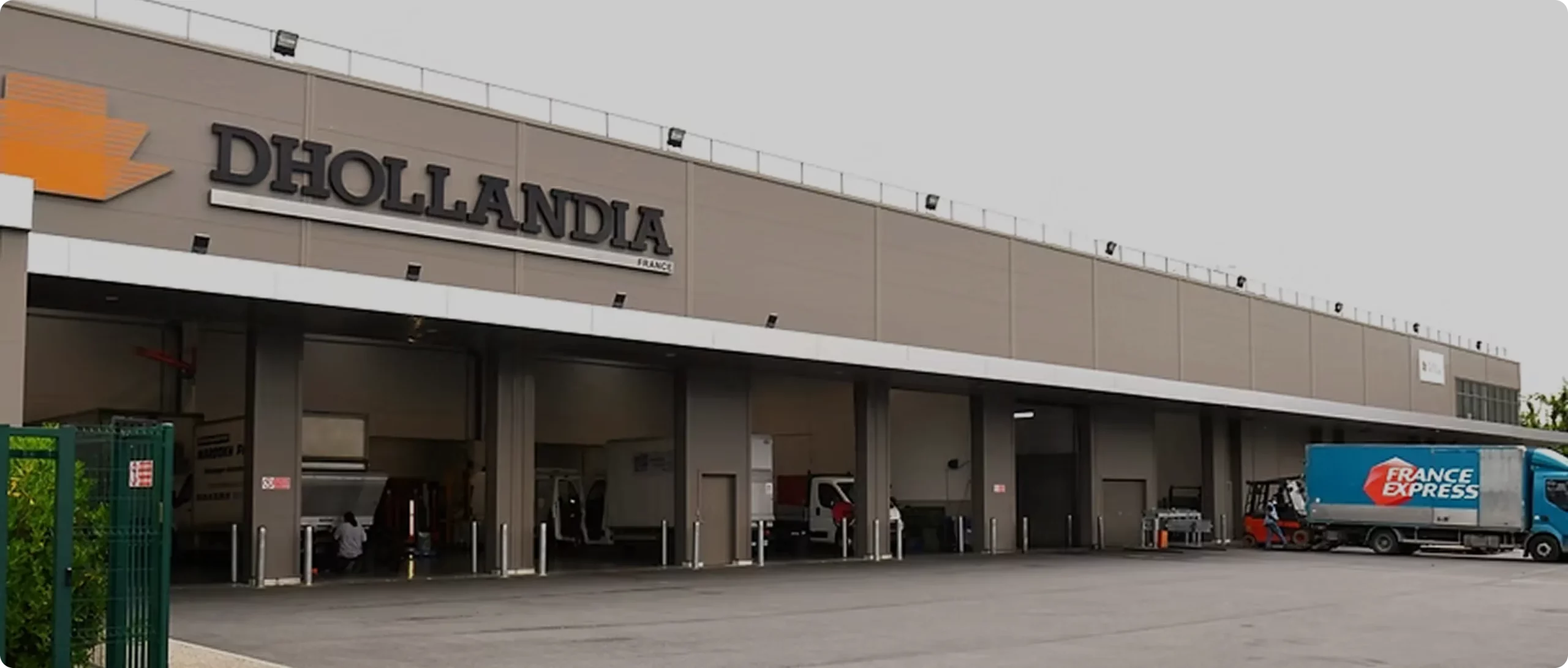 Bâtiment Dhollandia France avec ses baies d'atelier et un camion France Express