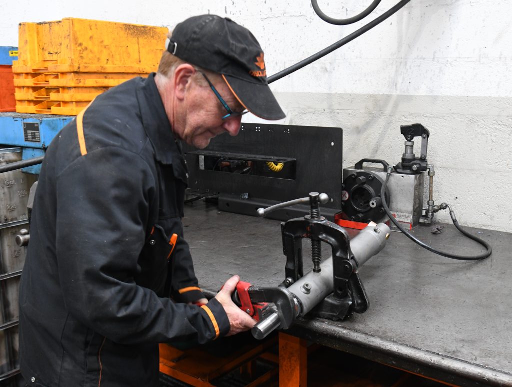 Technicien Dhollandia Services réparant le vérin d'un hayon élévateur en atelier