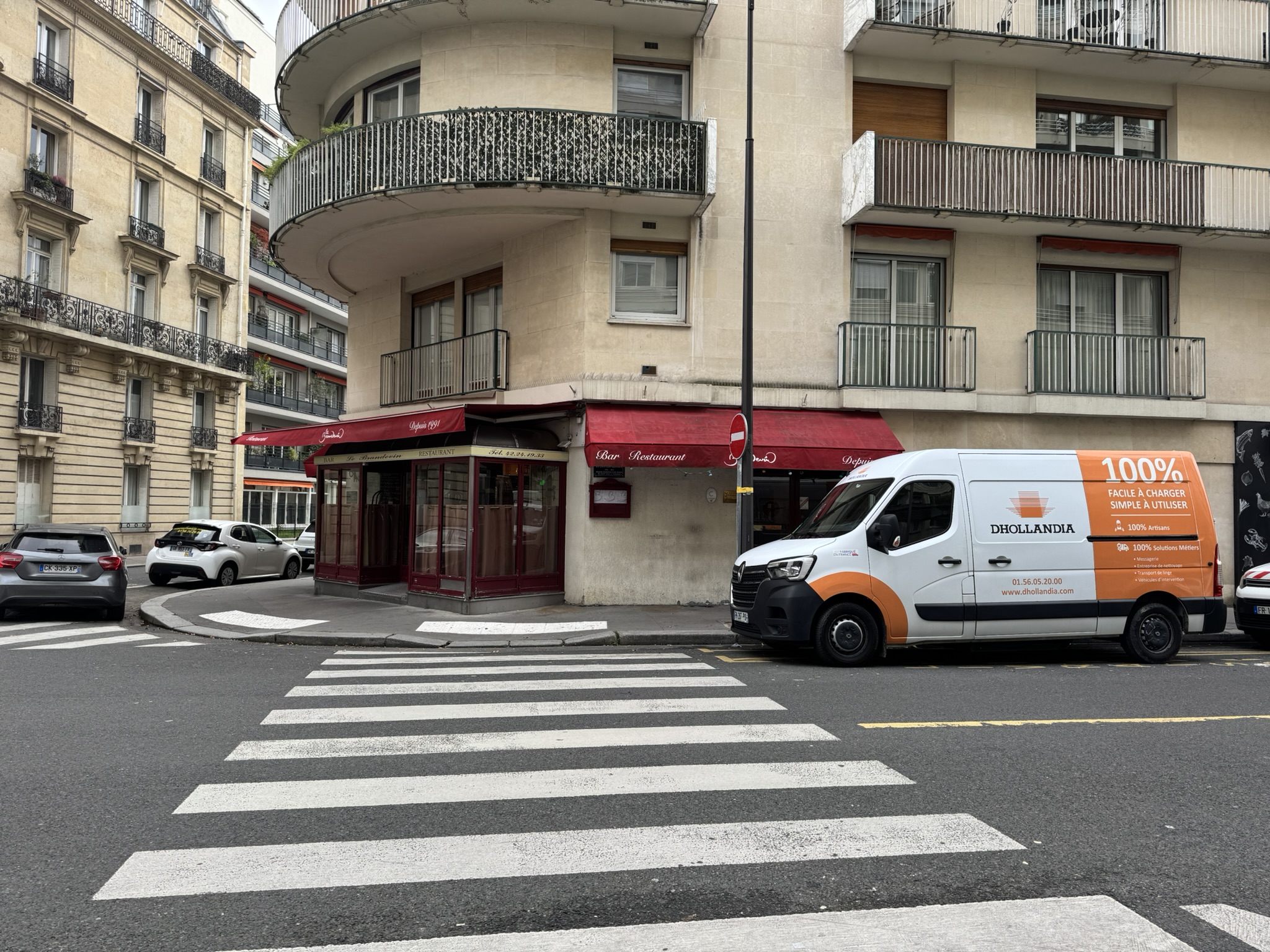 Fourgon Dhollandia Services stationné devant un immeuble parisien