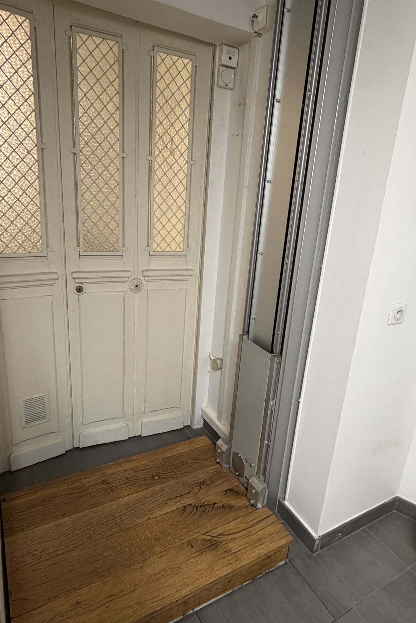 Monte-charge résidentiel discret intégré à côté d'une porte ancienne