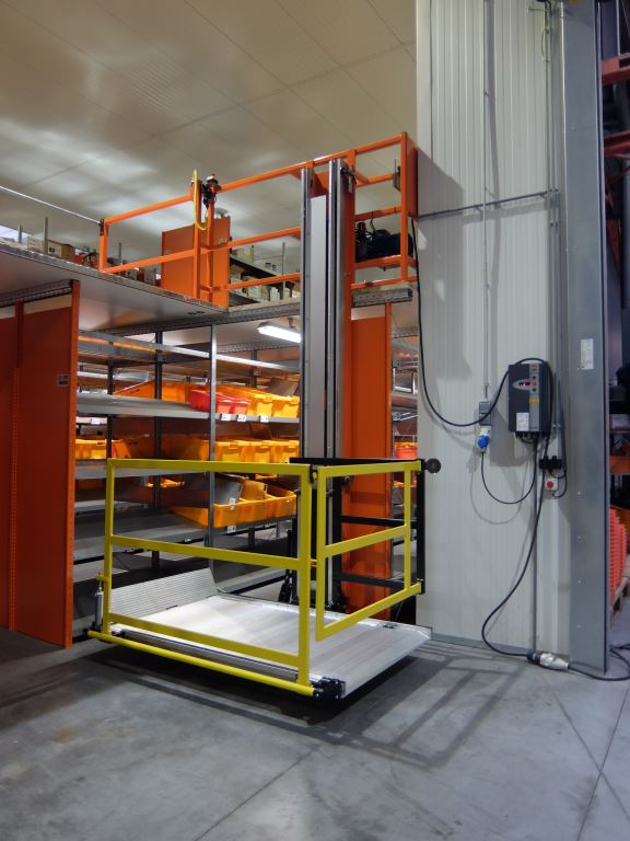 Monte-charge de mezzanine avec garde-corps jaune dans un entrepôt