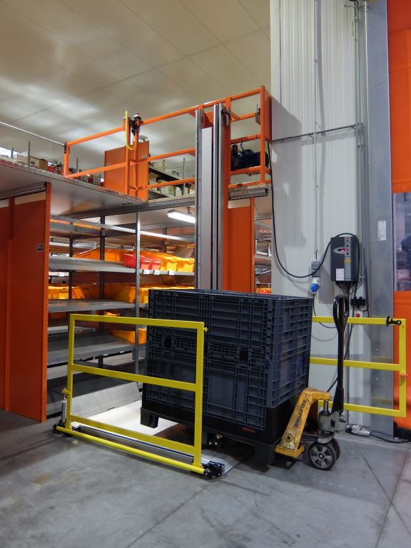 Monte-charge de mezzanine chargé d'un bac de manutention