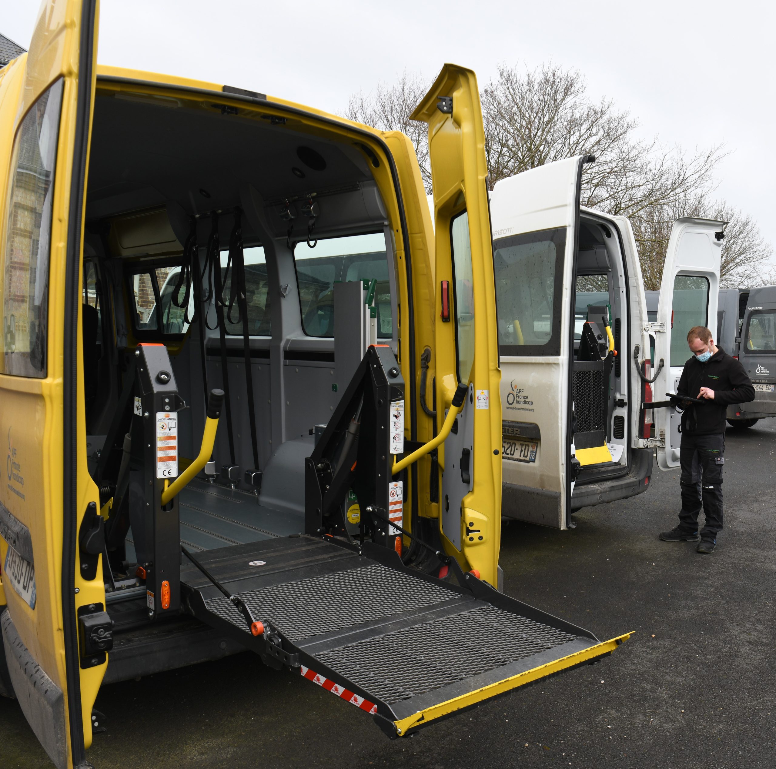 Lift PMR Dhollandia déployé à l'arrière d'un minibus jaune