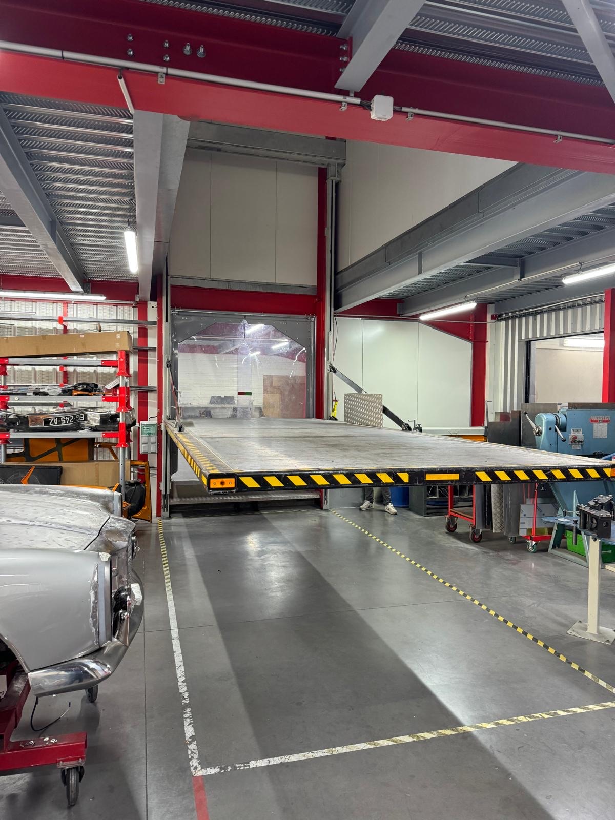 Élévateur de voiture Dhollandia à plateau dans un atelier automobile