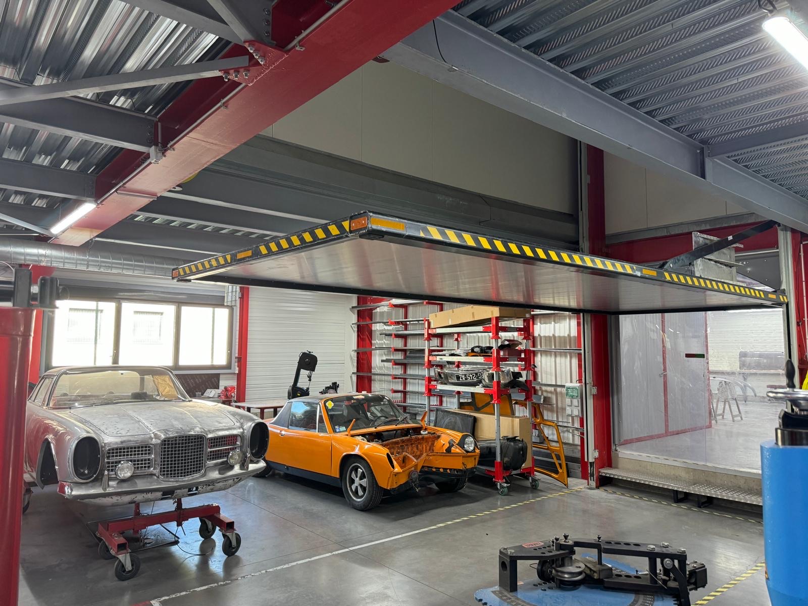 Élévateur de voiture en position haute au-dessus d'un atelier de restauration