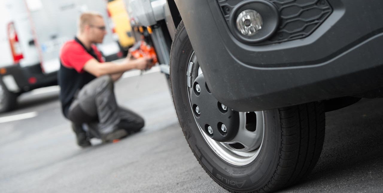 Technicien Dhollandia Services intervenant sur la roue d'un porteur en atelier