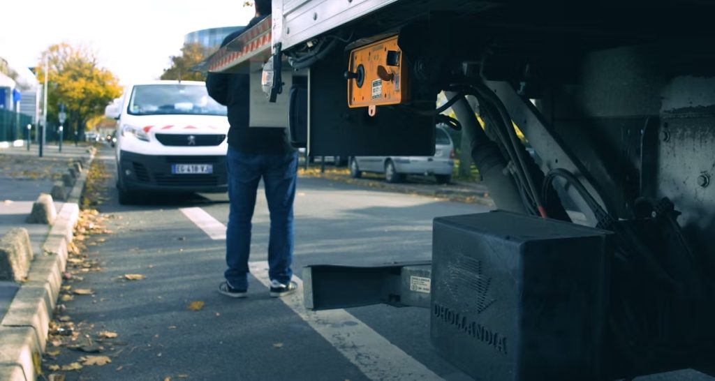 Technicien Dhollandia Services testant un hayon élévateur rétractable sur un camion