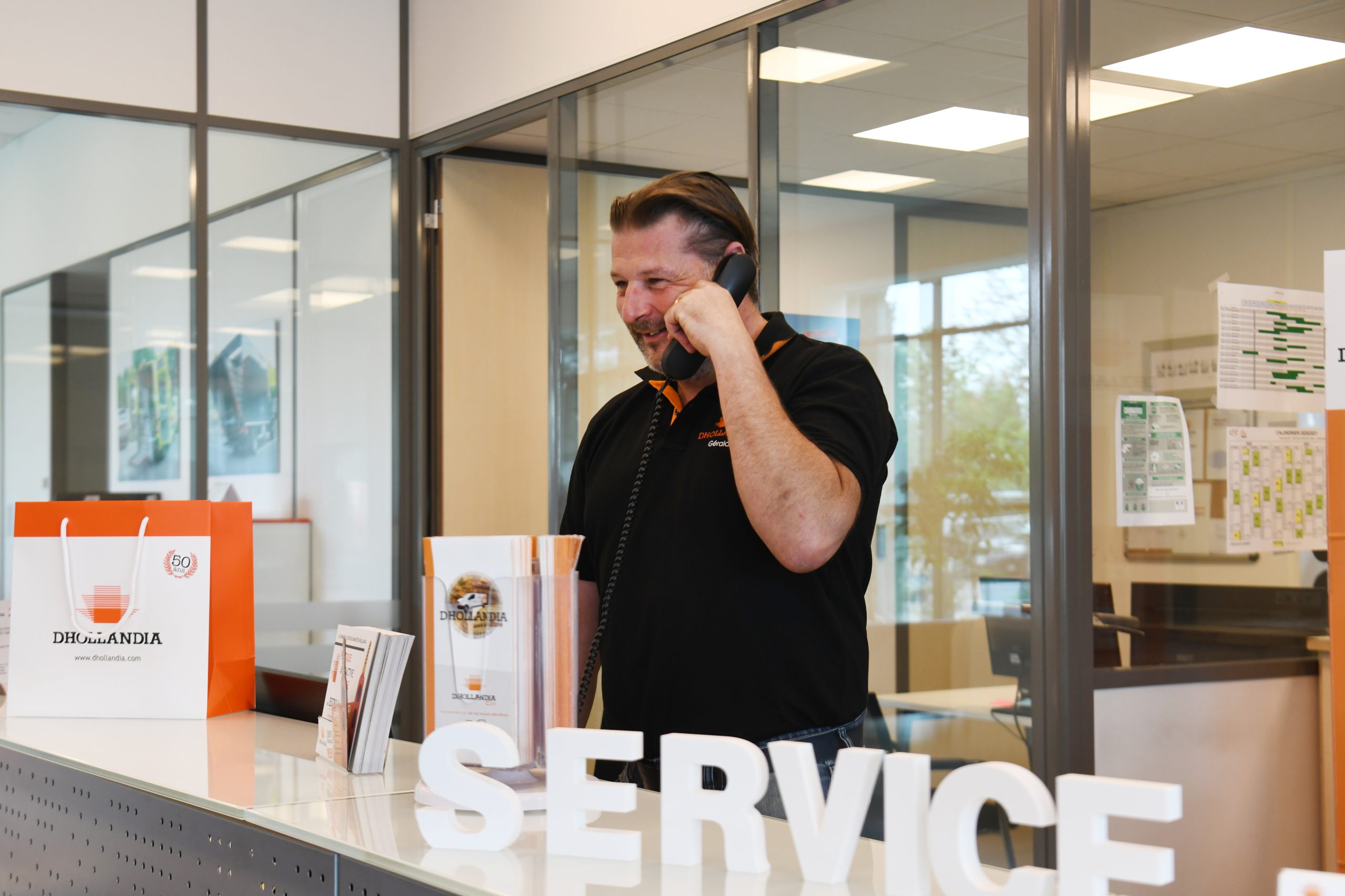 Conseiller Dhollandia Services au téléphone à l'accueil de l'agence