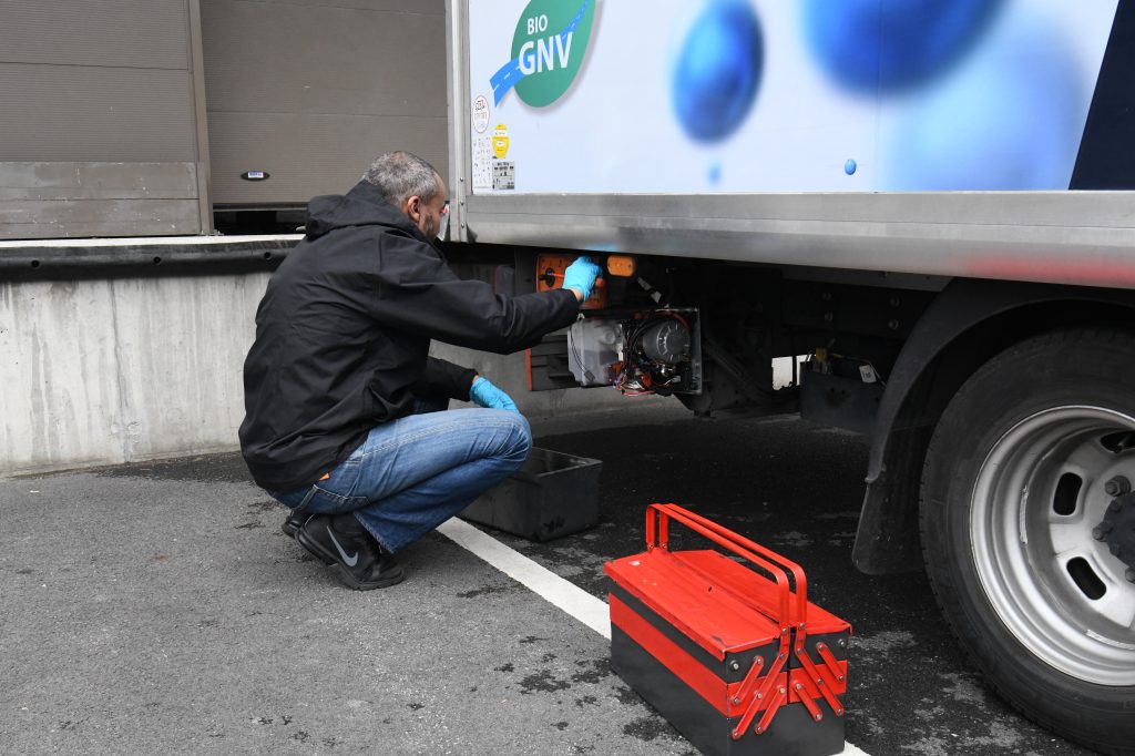 Technicien Dhollandia Services réparant un hayon élévateur sur site avec sa caisse à outils