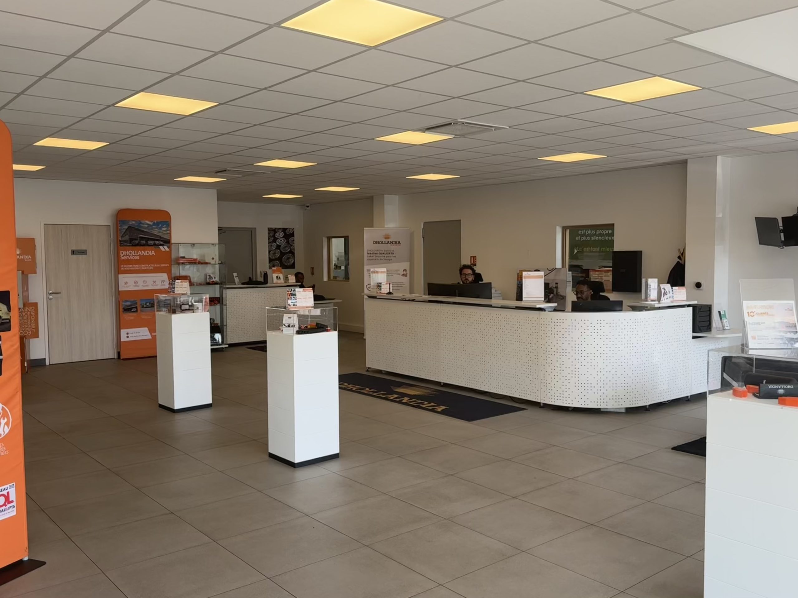 Accueil de l'agence Dhollandia Services avec comptoir et signalétique orange